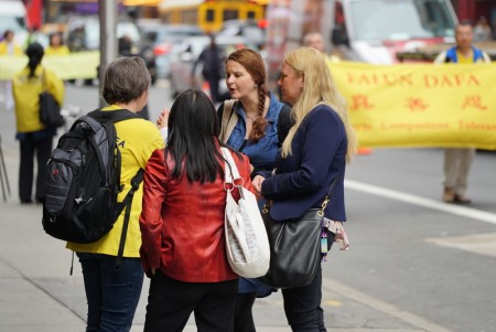 5月13日，近万名来自世界各地部分法轮功修炼学员在纽约曼哈顿参加庆祝“5•13”世界法轮大法日大游行。法轮功学员向路人讲真相。（谢东延 ／大纪元）